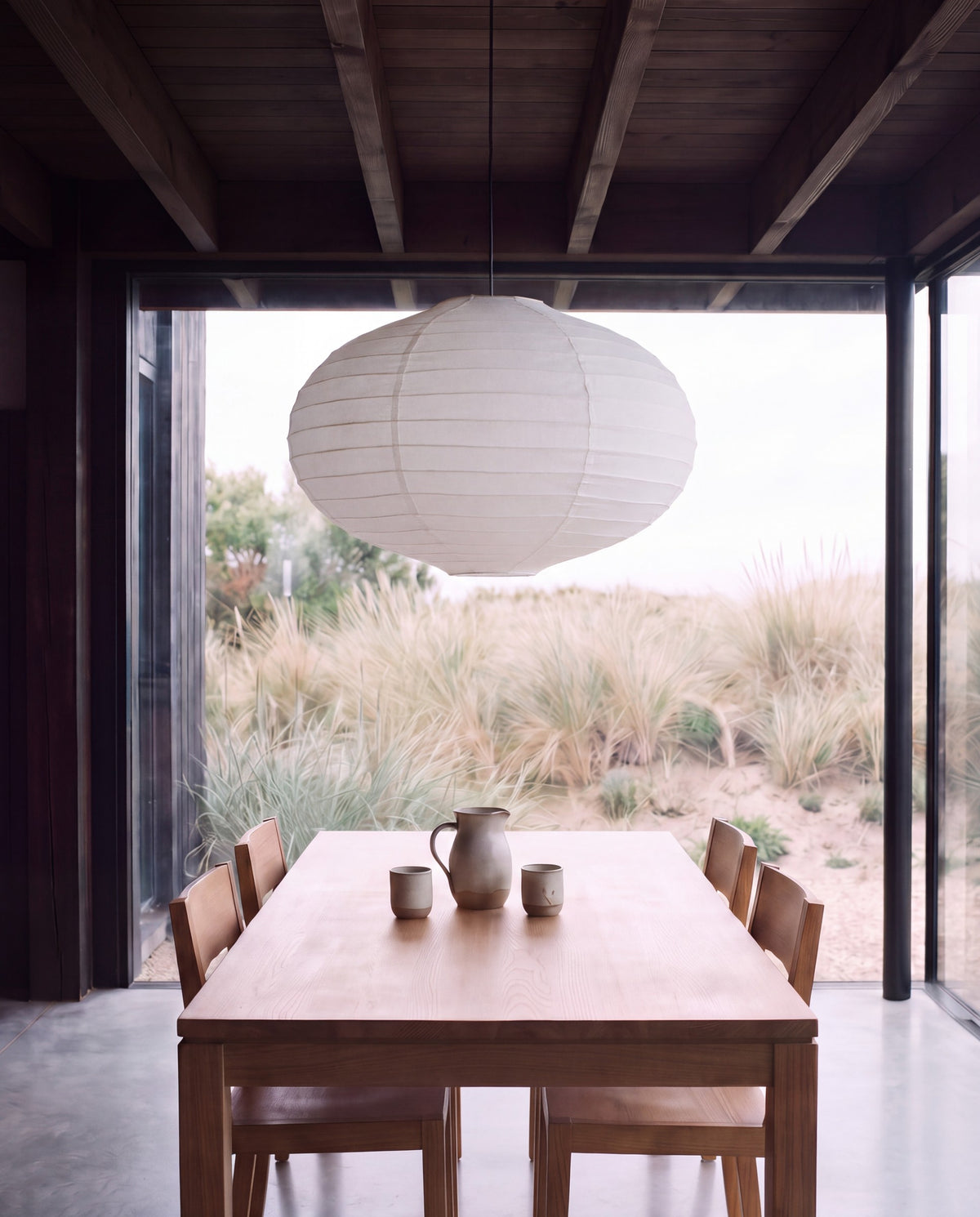 Lámpara Kumo Grande — lino blanco, forma ovalada 65 × 40 cm, sobre la mesa del comedor